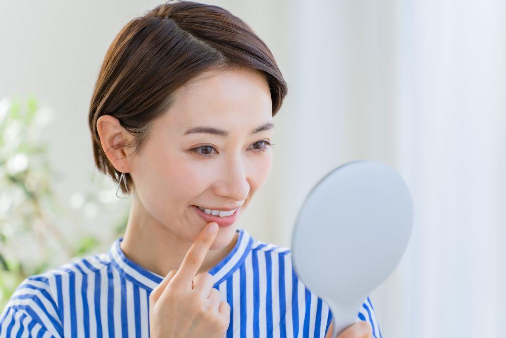 手鏡で歯をチェックする女性