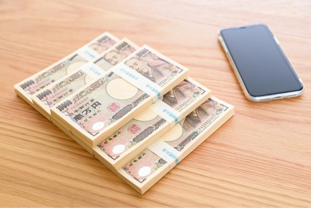 10,000円の束とスマホ